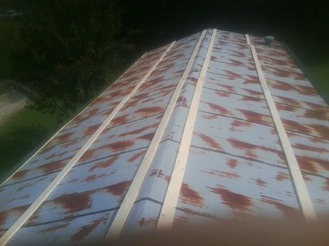 Rusted metal roof panels with new wood purlins before replacement — Storm Damage Roof Repair in Craig by Roofing Brothers